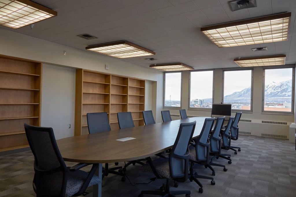 A meeting room with a long table and chairs